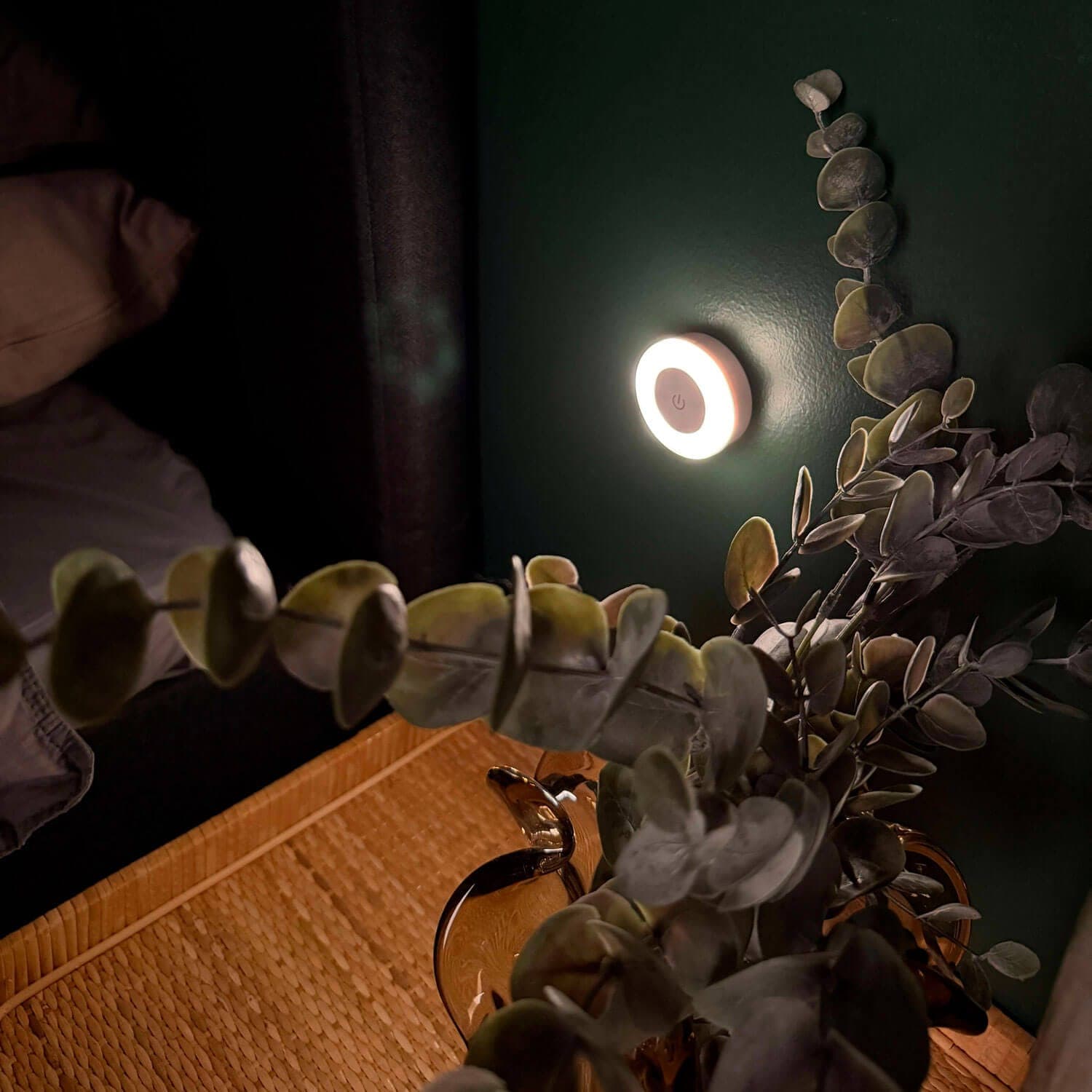 Lámpara de lactancia redonda que proyecta una luz tenue sobre la pared junto a la cama por la noche