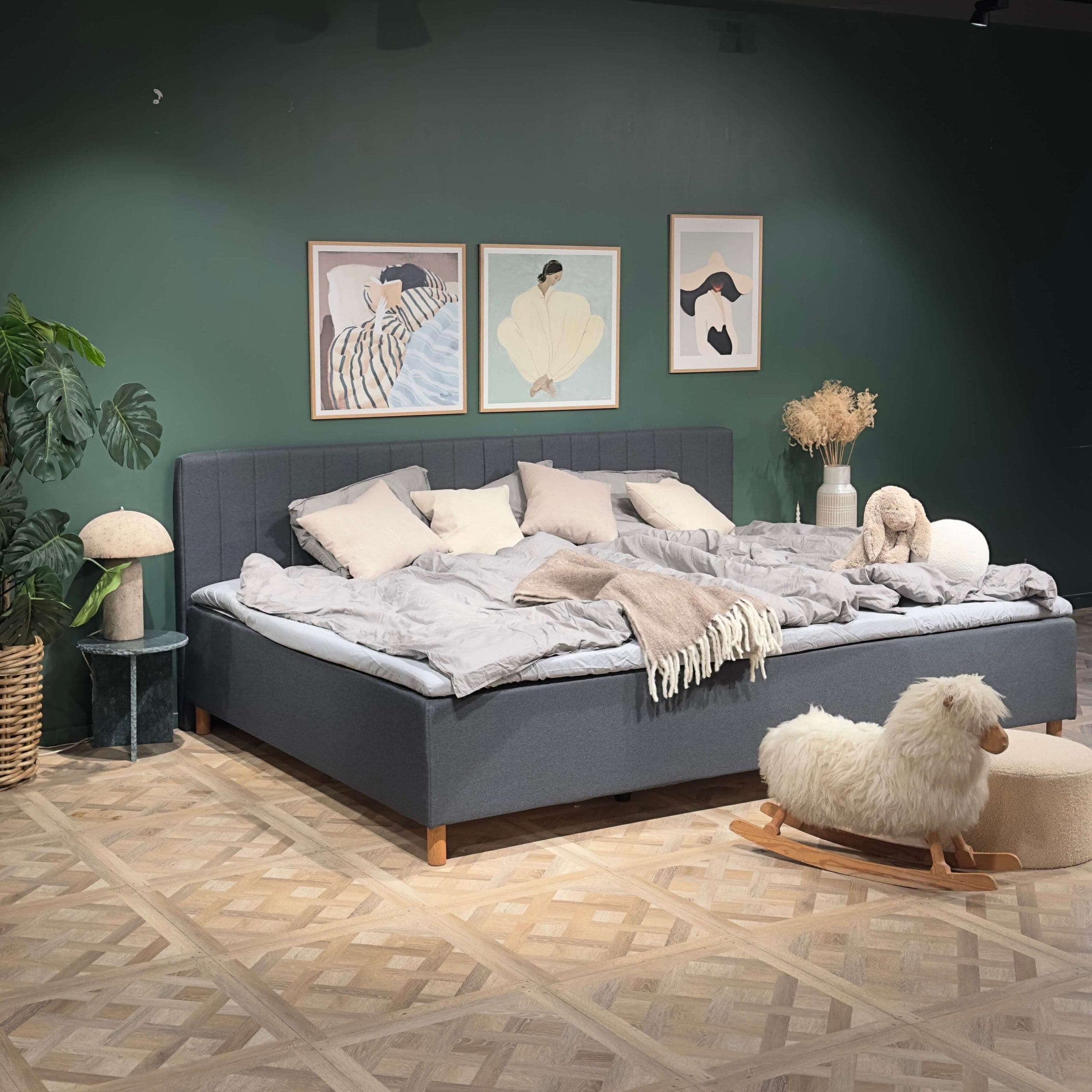 Dark grey FamBed headboard with vertical upholstered panels behind a neatly made family bed.