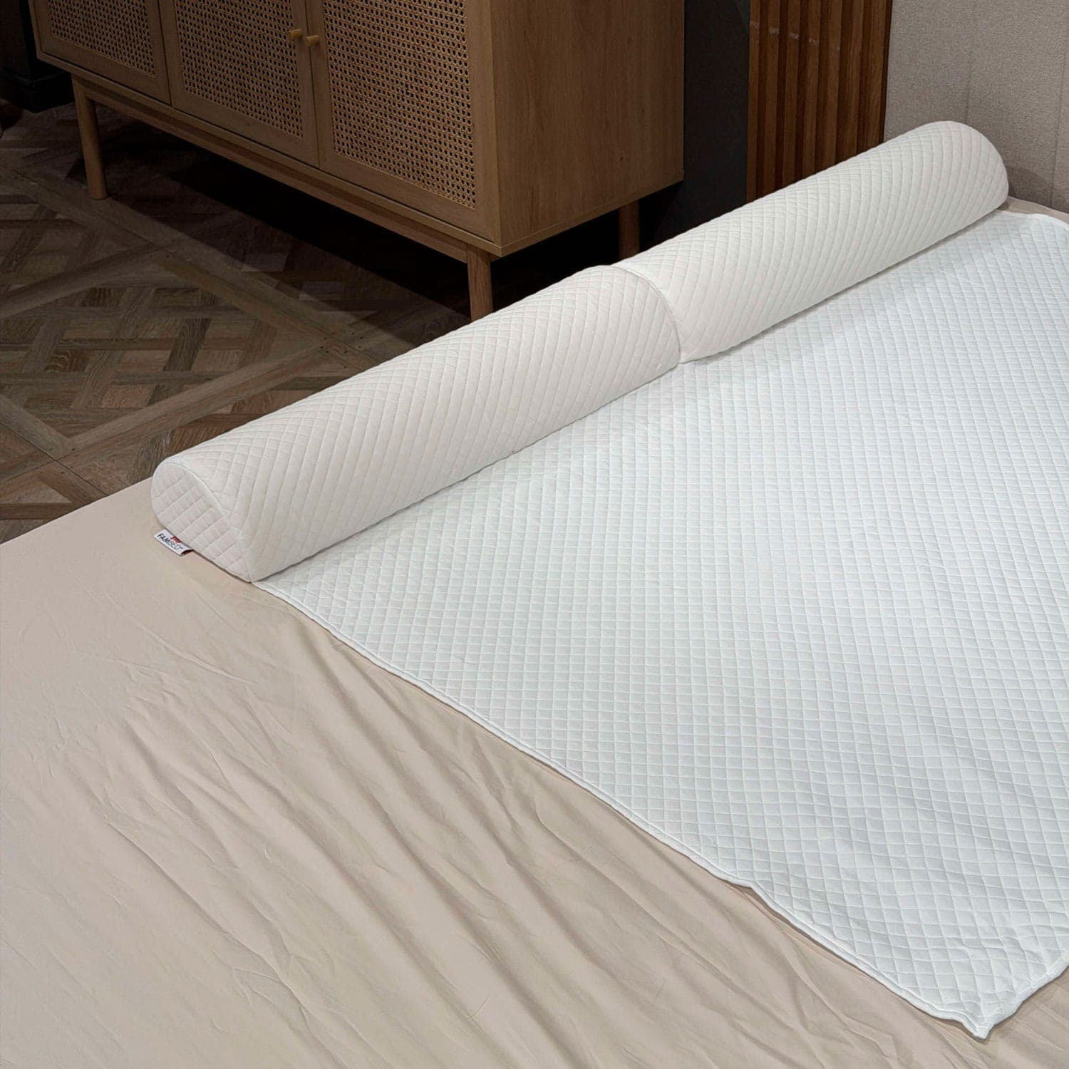 Quilted foam bed guard fitted beneath the white mattress topper cover along the edge of the bed