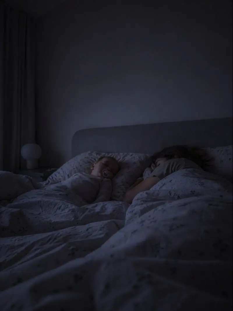 Una pareja y su hijo duermen juntos en la cama bajo una tenue luz nocturna