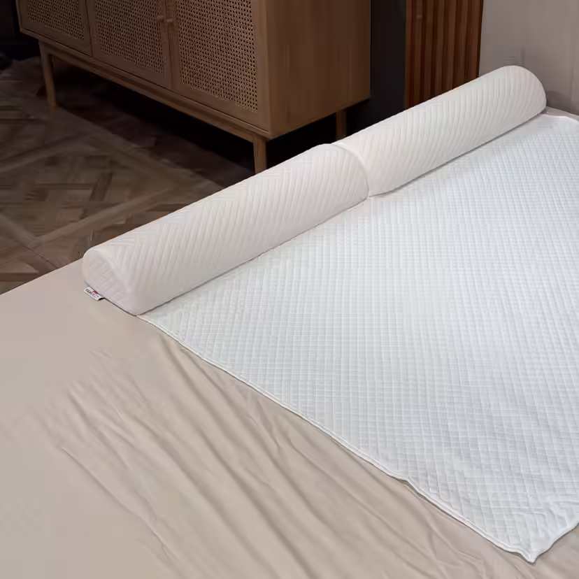 Quilted foam bed guard fitted beneath the white mattress topper cover along the edge of the bed
